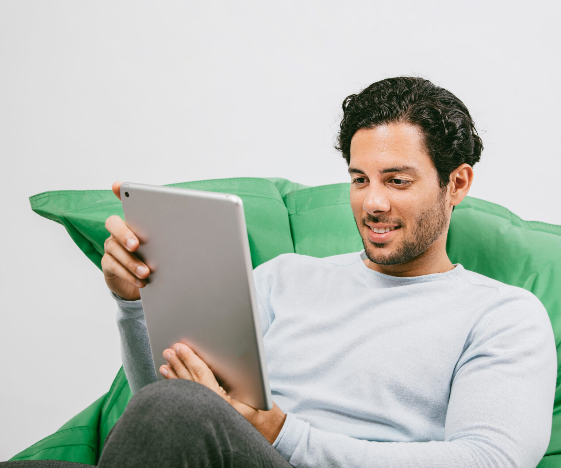 Persona leyendo en una tablet en su sofá